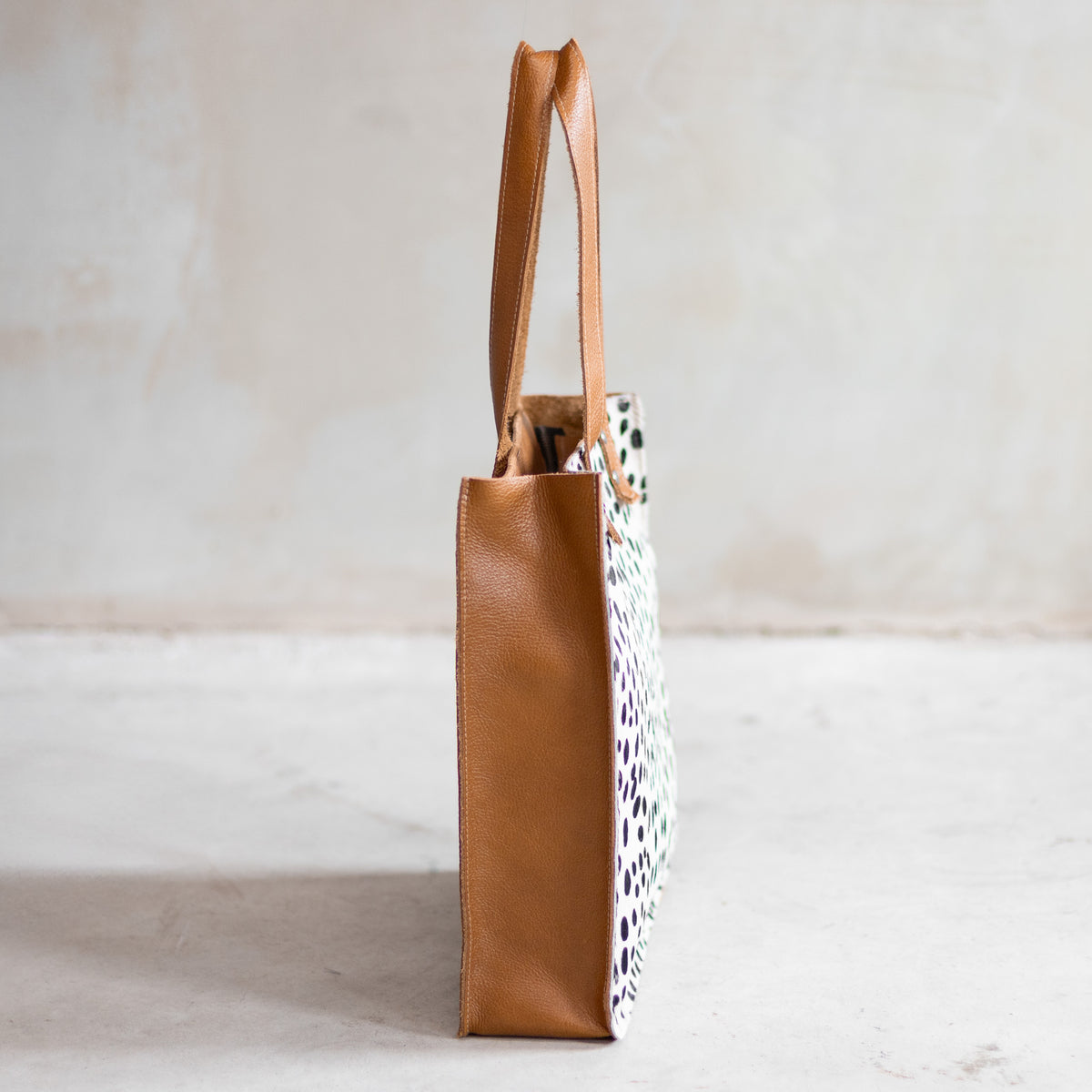 Sac à main cabas en cuir et peau de vache dalmatien, vu de profil