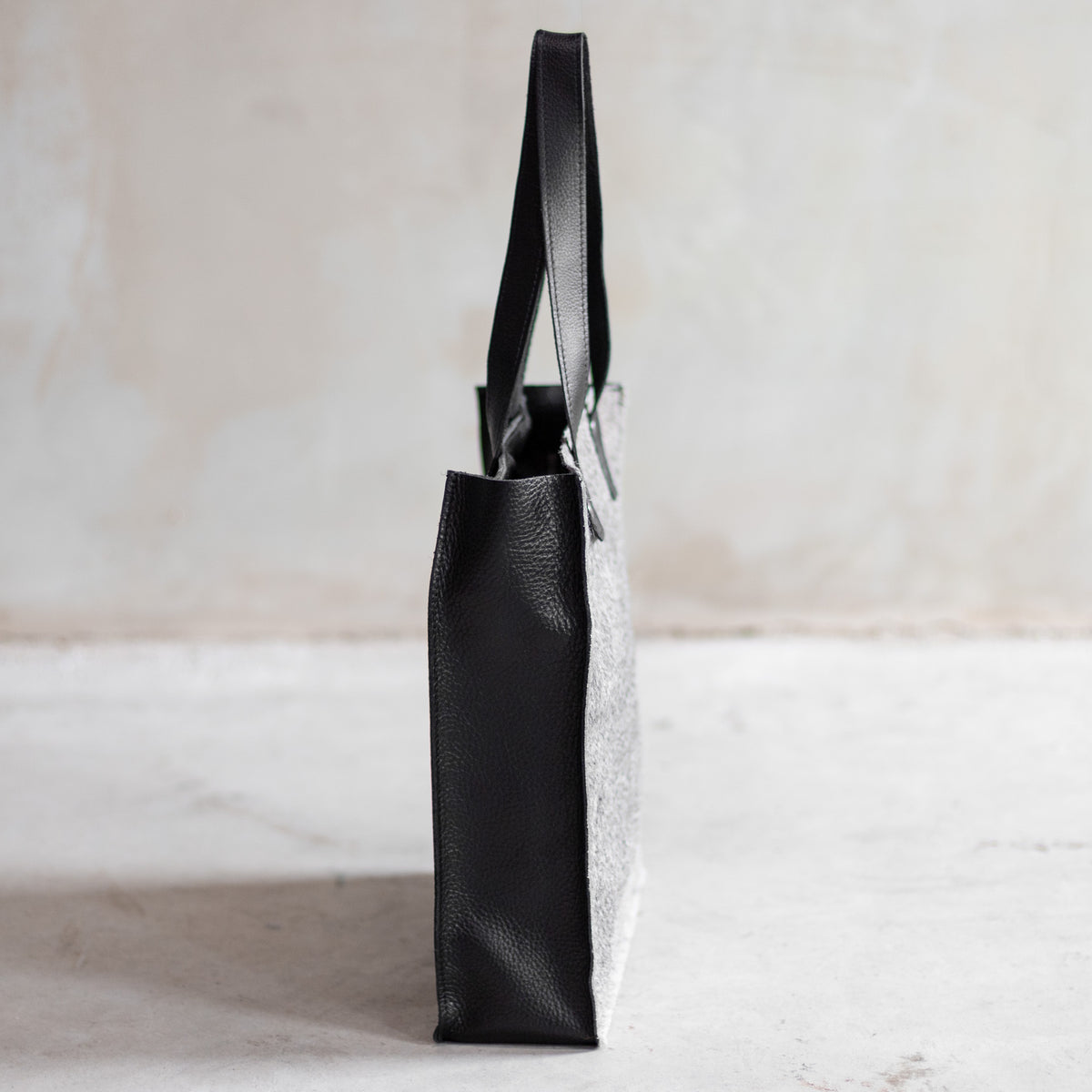 Sac à main cabas en cuir et peau de vache grise, vu de profil