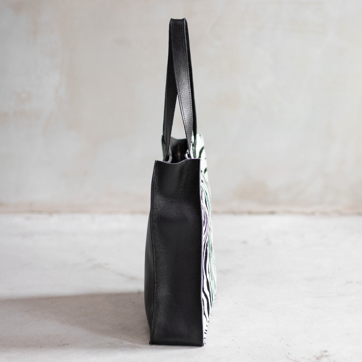 Sac à main cabas en cuir et peau de vache zèbre, vu de profil