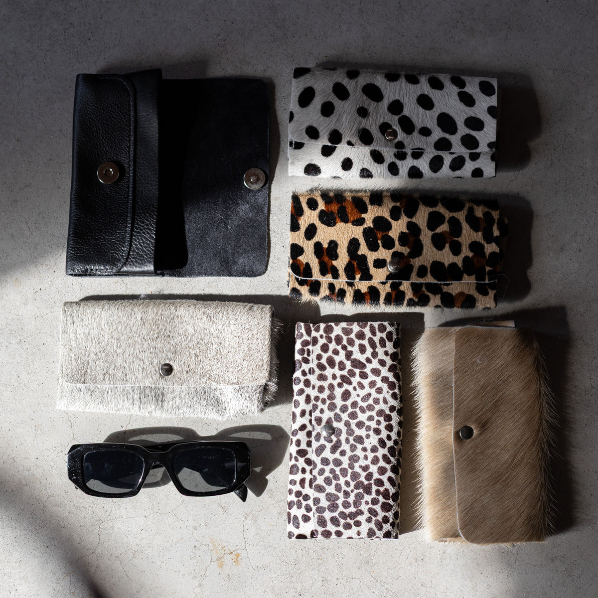Étui à lunettes aimanté en cuir sable, étuis à lunettes aimantés posés sur une table en bois