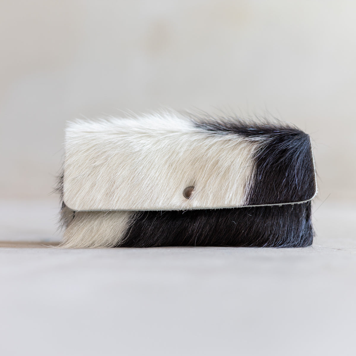 Étui à lunettes aimanté en peau de vache noir et blanc, vu de face, fermeture aimantée