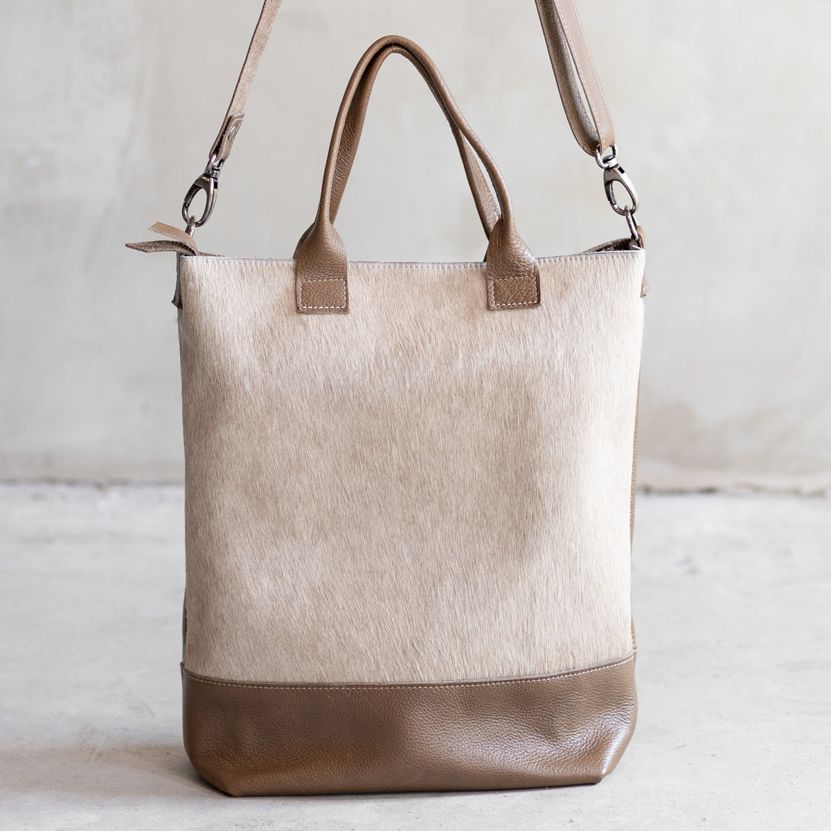 Grand sac à main en cuir et peau de vache crème, vu de face avec anses et bandoulière