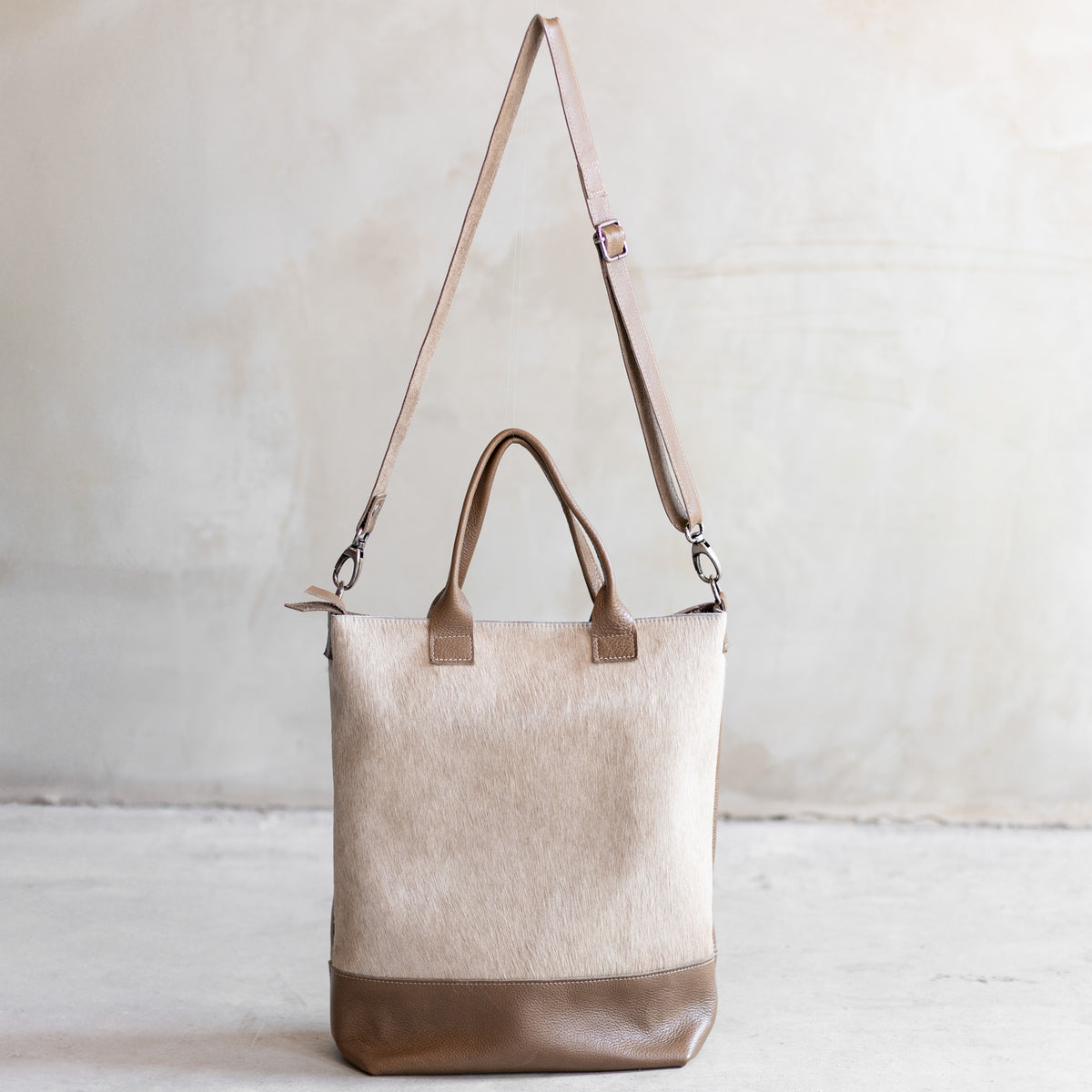 Grand sac à main en cuir et peau de vache crème, vu de face avec sa bandoulière en cuir taupe
