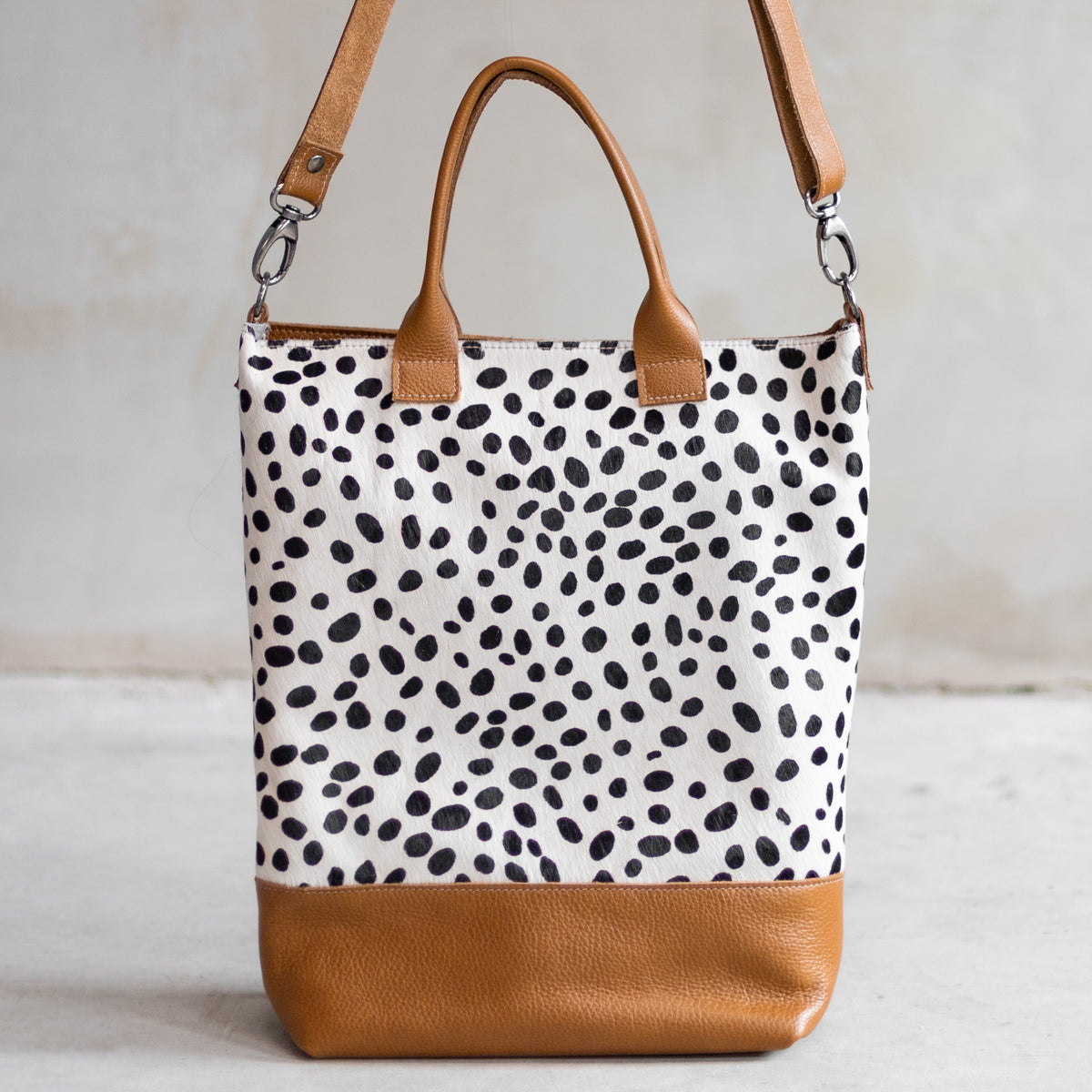Grand sac à main en cuir et peau de vache dalmatien, vu de face avec anses et bandoulière
