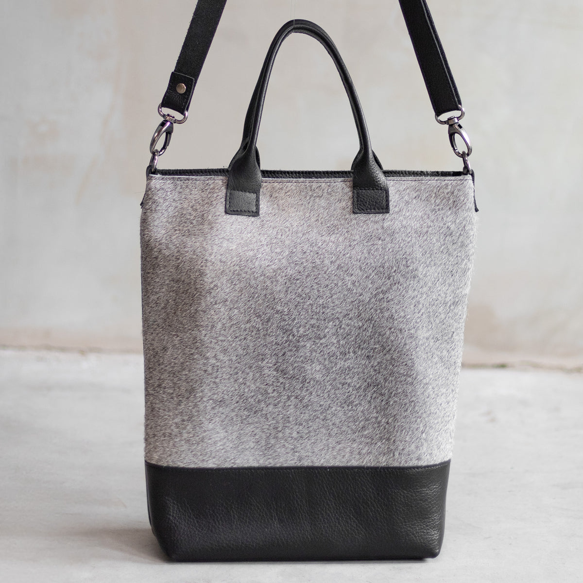 Grand sac à main en cuir et peau de vache grise, vu de face avec anses et bandoulière