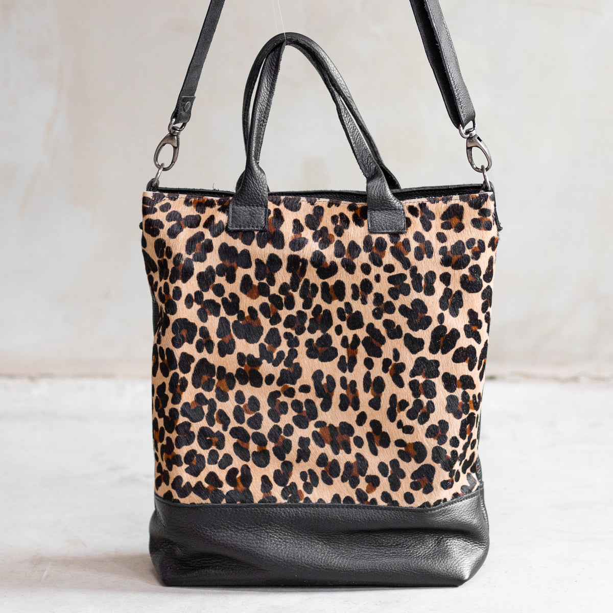 Grand sac à main en cuir et peau de vache léopard, vu de face avec anses et bandoulière