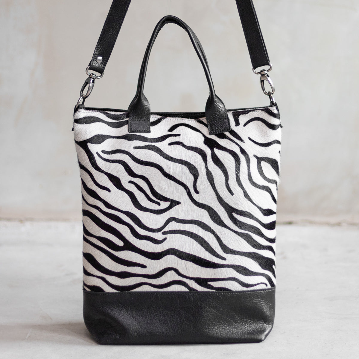Grand sac à main en cuir et peau de vache zèbre, vu de face avec anses et bandoulière