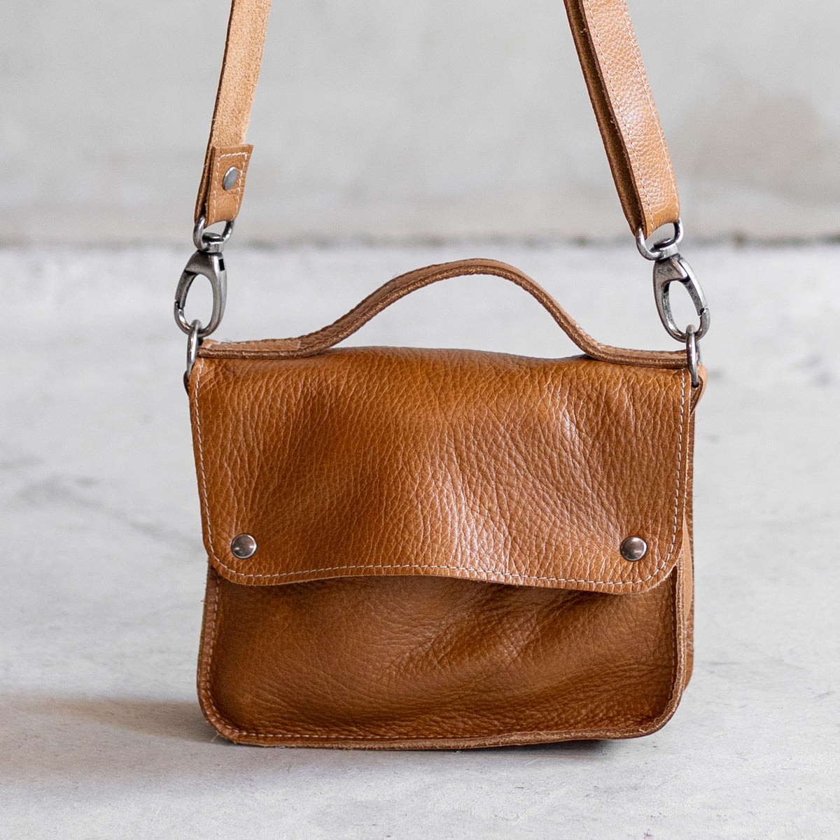 Petit sac à main bandoulière en cuir cognac, vu de face avec poignée et bandoulière
