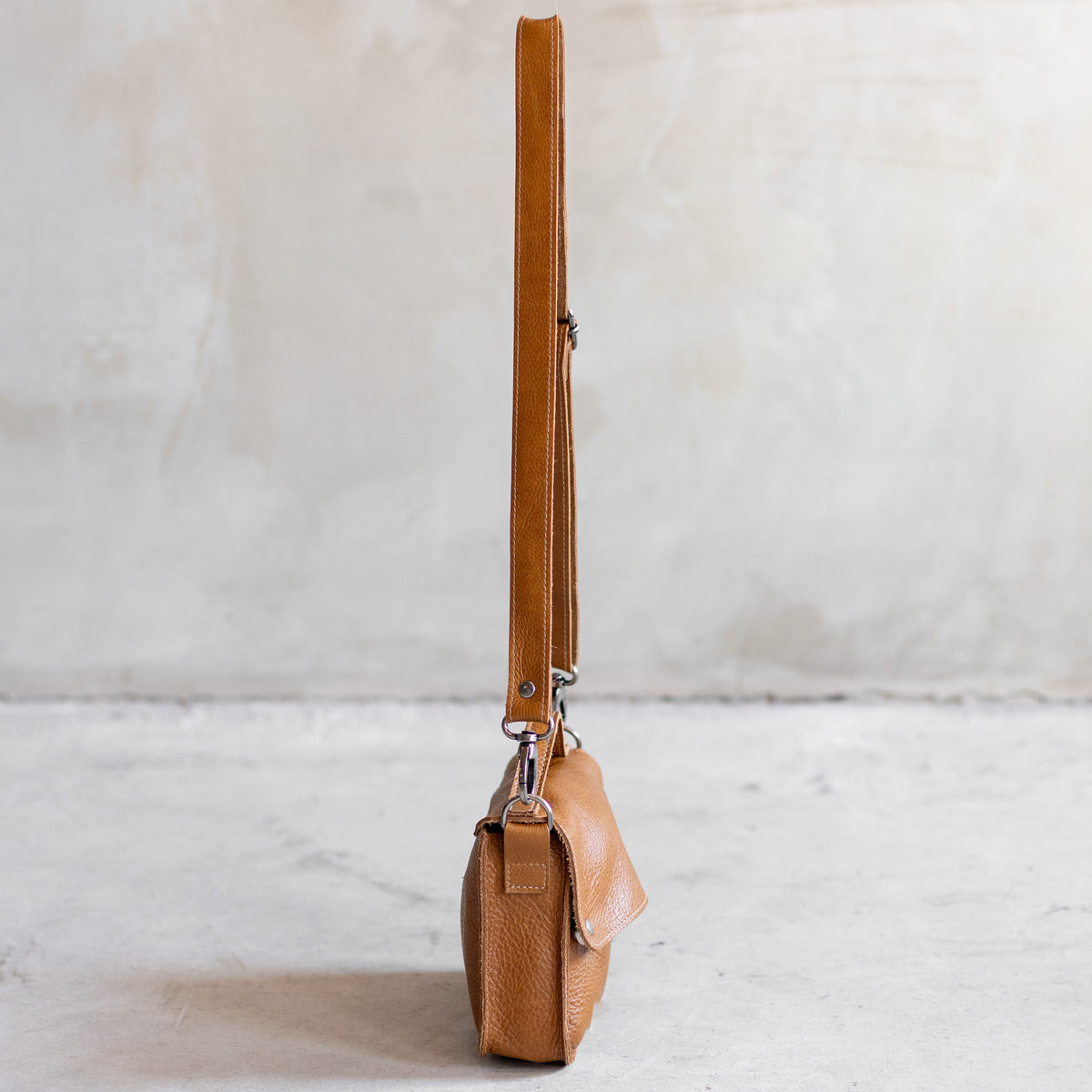 Petit sac à main bandoulière en cuir cognac, vu de profil