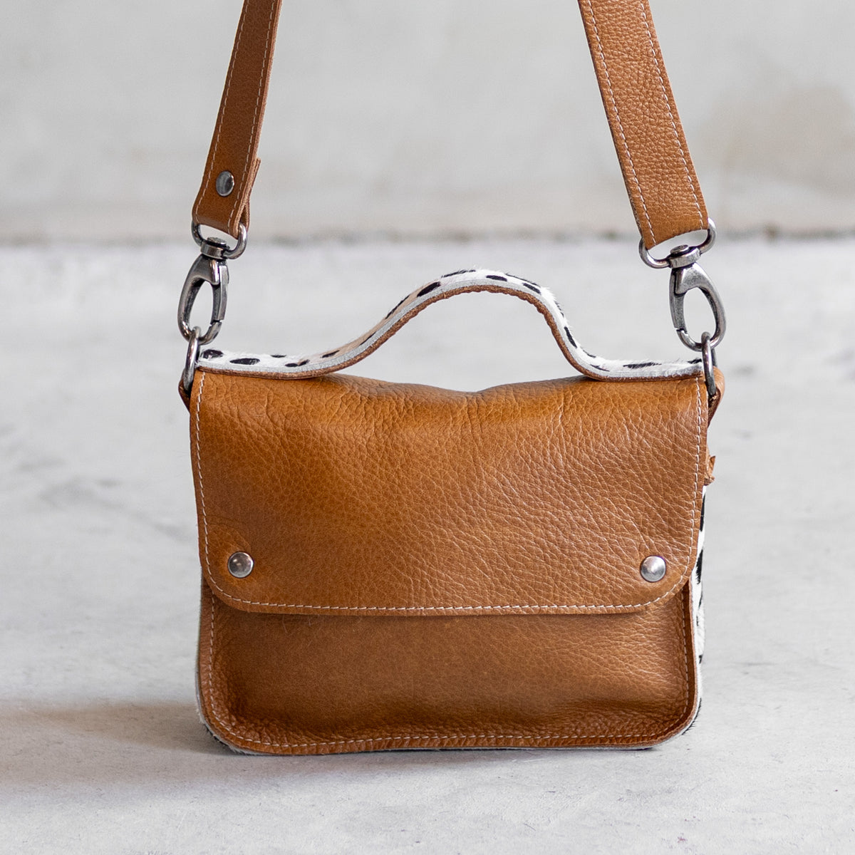 Petit sac à main bandoulière en cuir cognac et côtés dalmatien, vu de face, poignée dalmatien