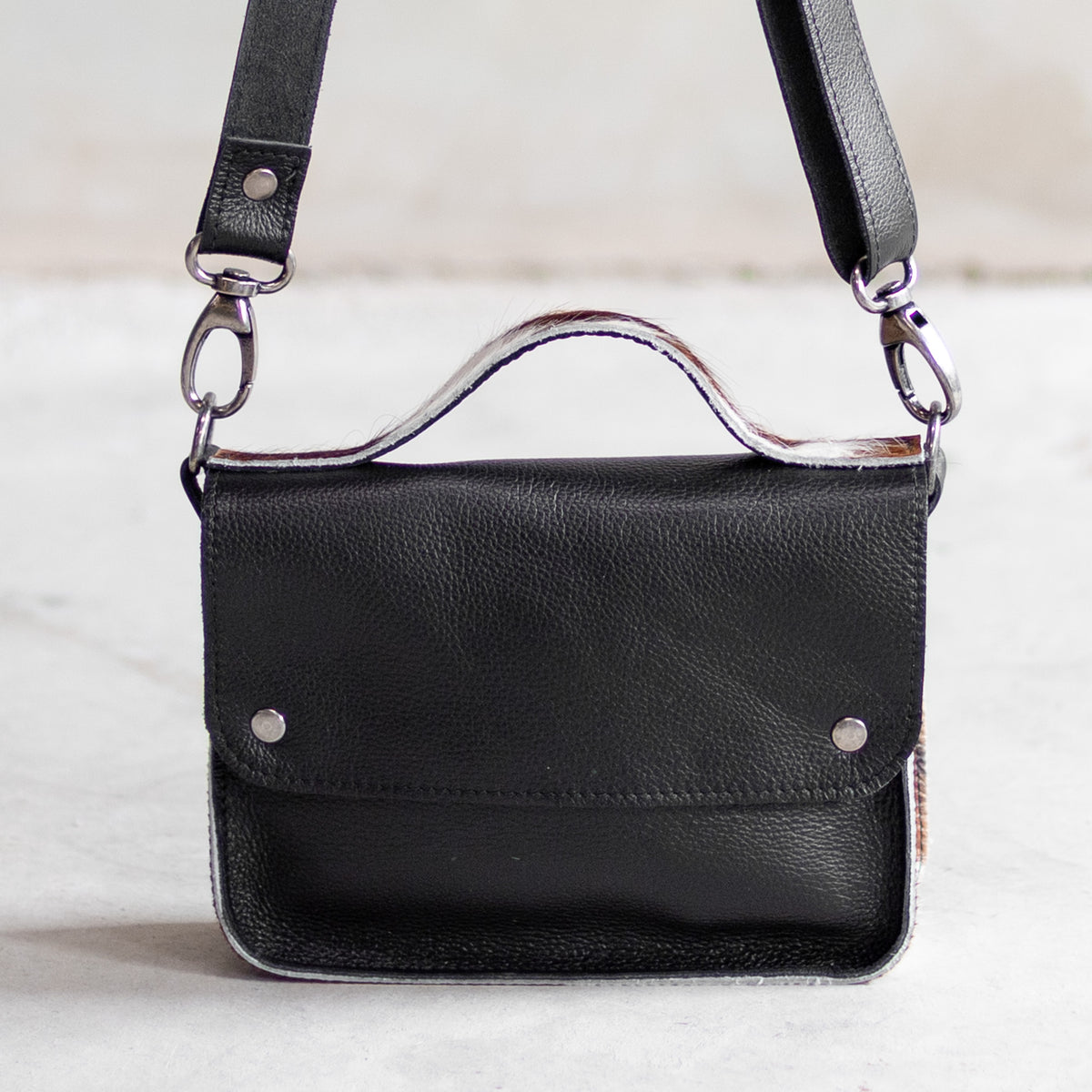 Petit sac à main bandoulière en cuir noir et côtés tricolores, vu de face avec poignée et bandoulière