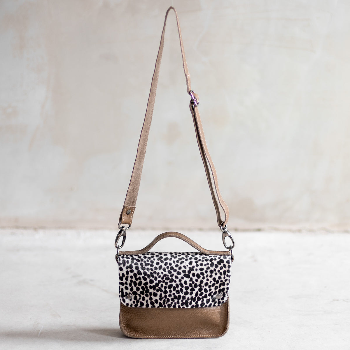 Petit sac à main bandoulière en cuir sable et rabat mini dalmatien, vu de loin avec sa bandoulière