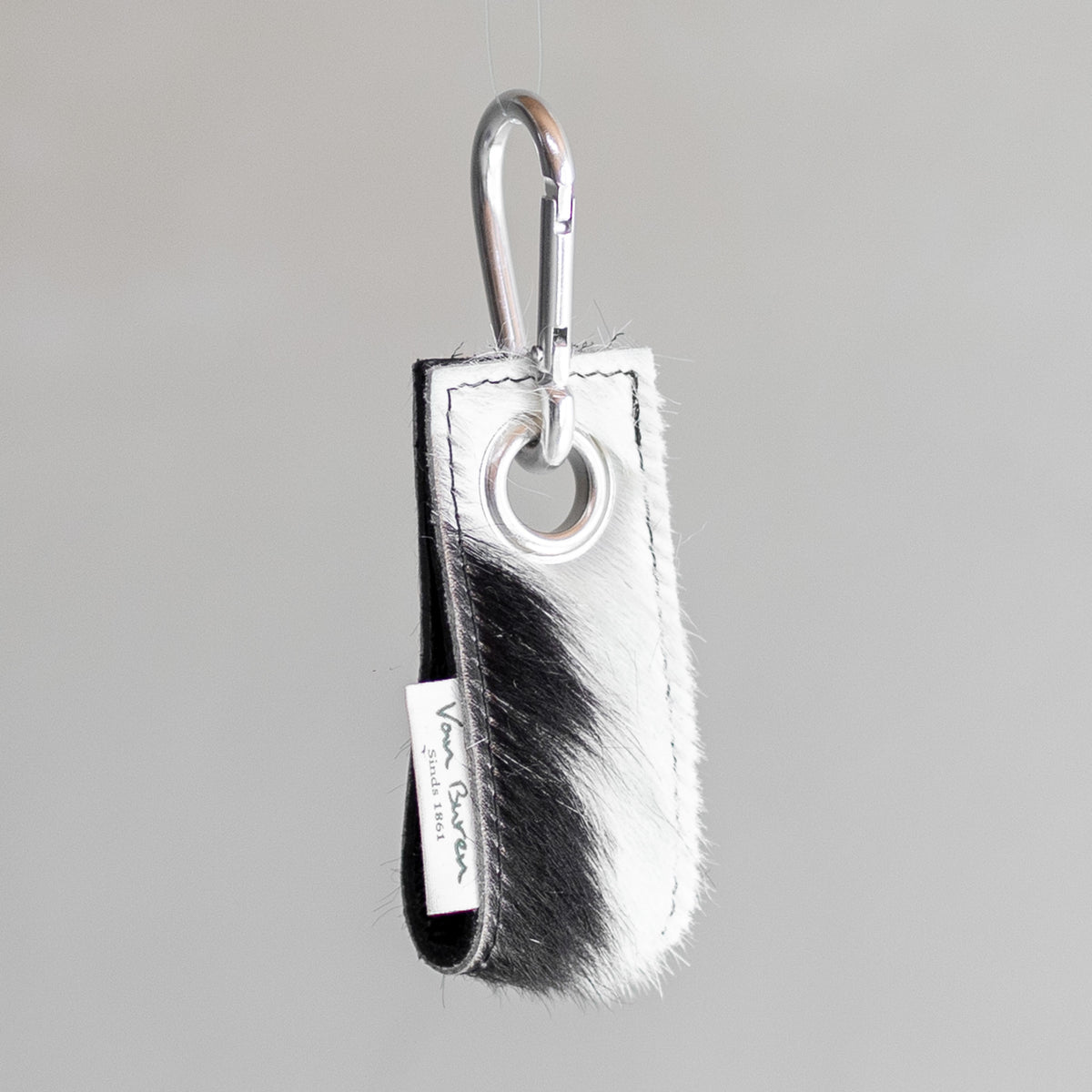 Porte-clés en peau de vache noir et blanc, vu de profil
