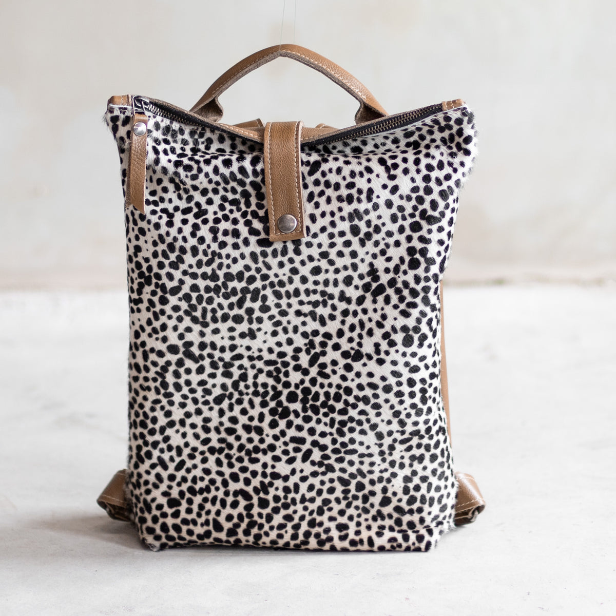 Sac à main à dos en cuir et peau de vache mini dalmatien, vu de face, poignée en cuir cognac