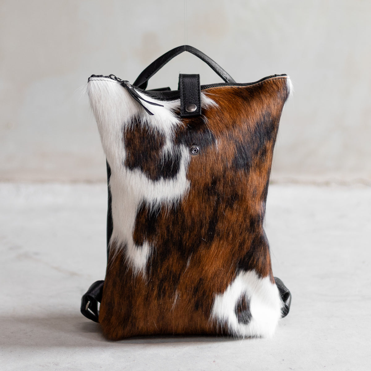 Sac à main à dos en cuir et peau de vache tricolore, vu de face