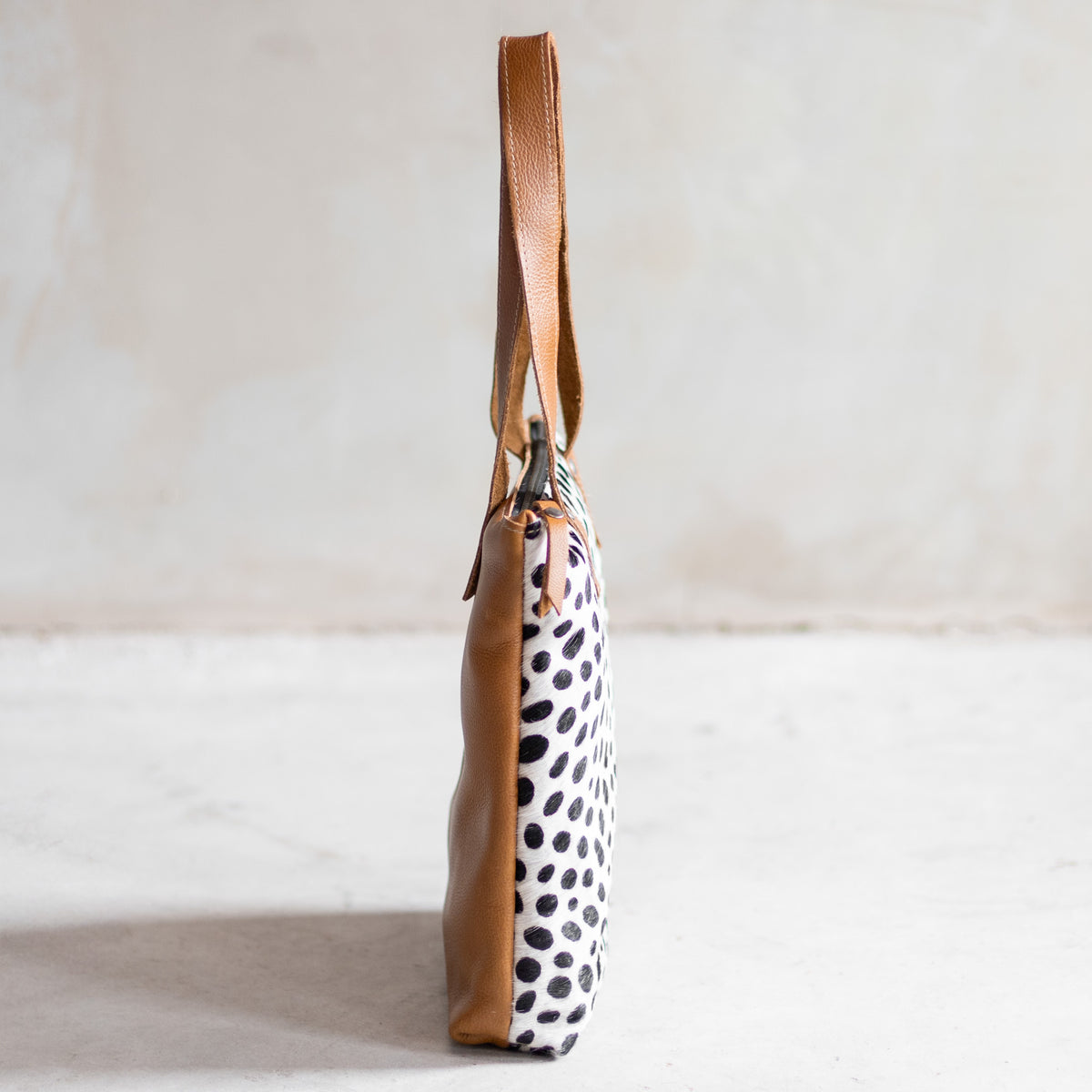 Sac à main épaule zippé en cuir et peau de vache dalmatien, vu de profil