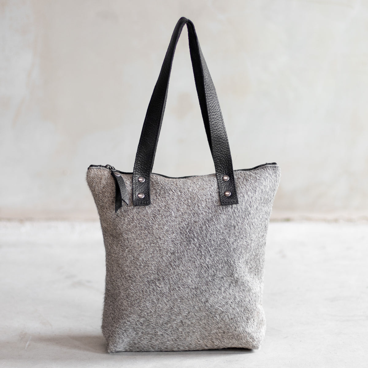 Sac à main épaule zippé en cuir et peau de vache grise, façade grise vue de face