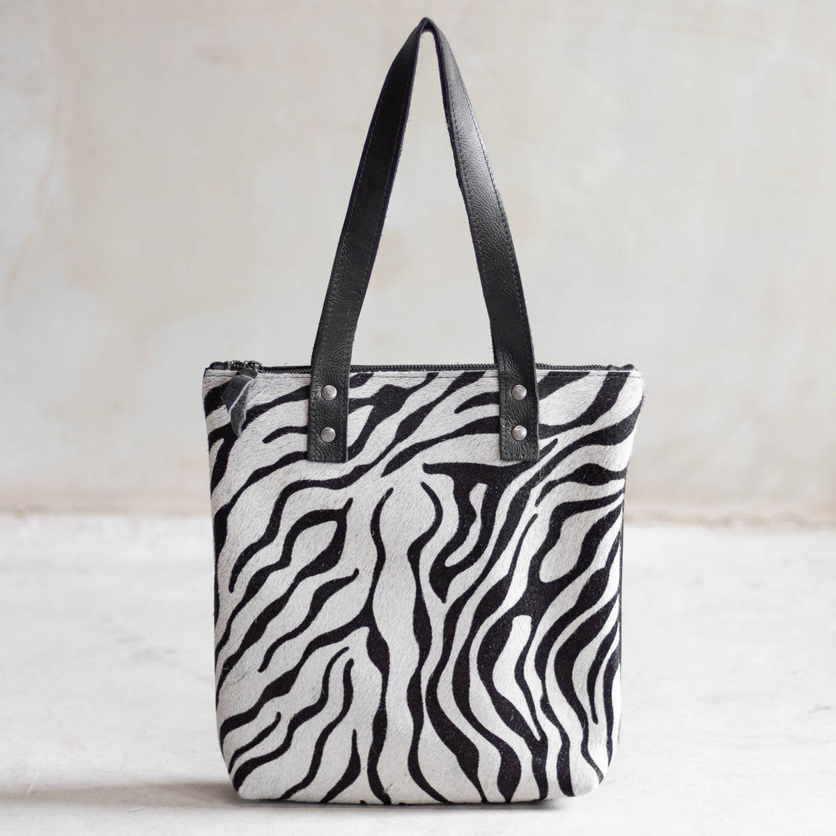 Sac à main épaule zippé en cuir et peau de vache zèbre, façade zébrée vue de face