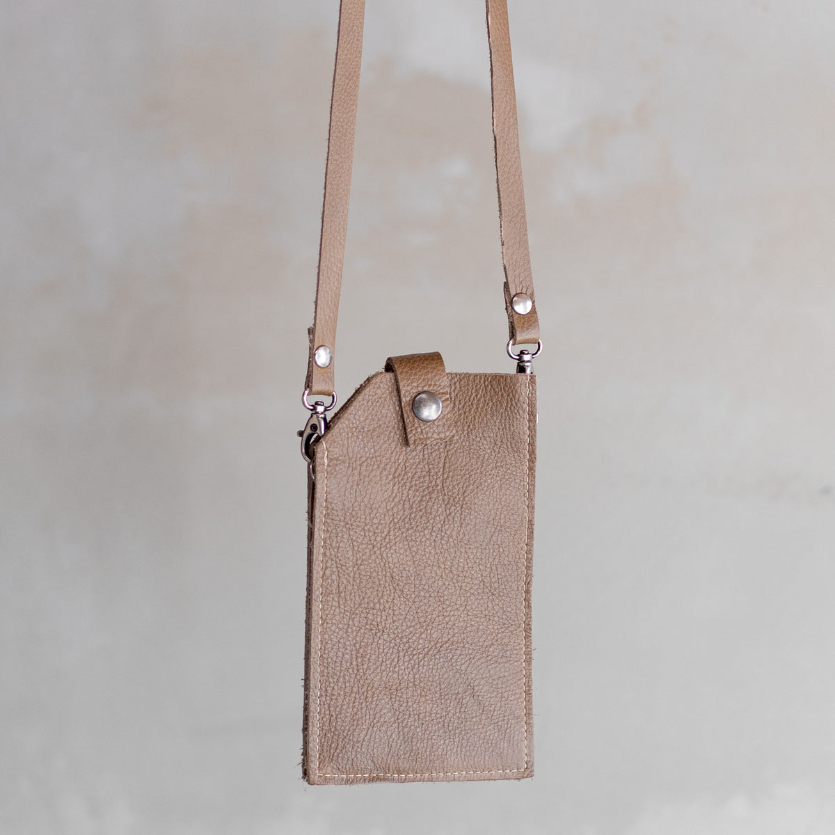Sac à main pochette téléphone en cuir sable, suspendue par sa bandoulière