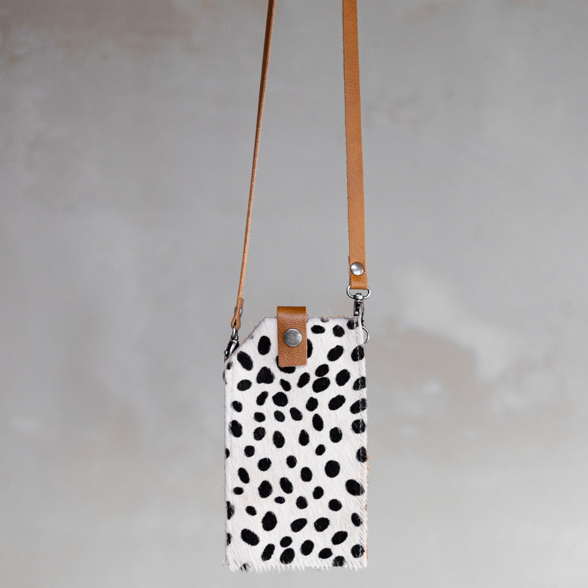 Sac à main pochette téléphone en peau de vache dalmatien, suspendue par sa bandoulière