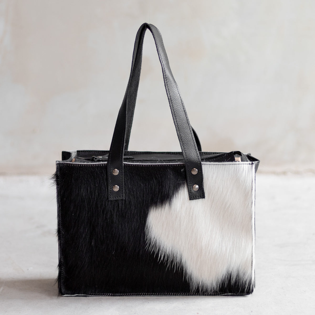 Sac à main rectangulaire en cuir noir et peau de vache noir et blanc, vu de face